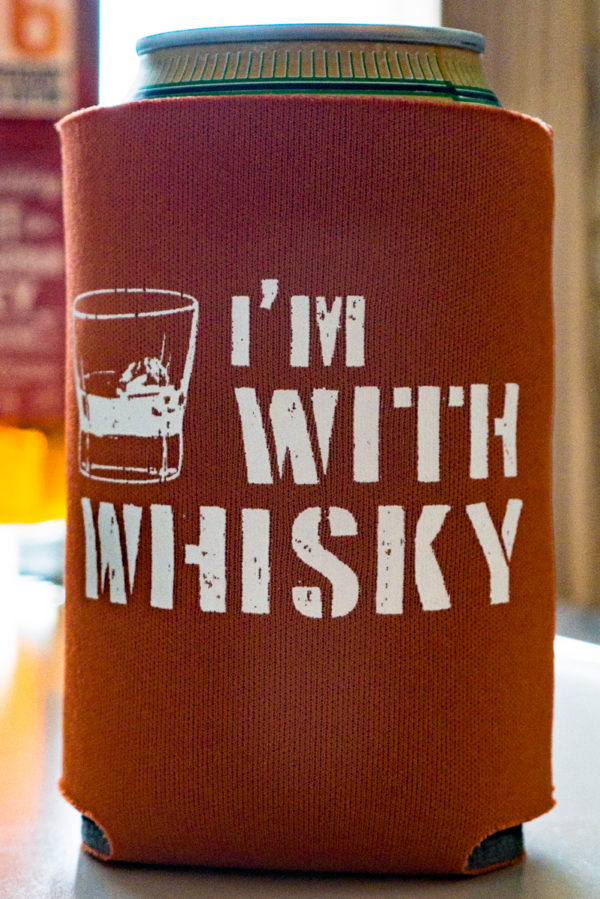 “I’m With Whisky” Sidekick Sleeve. Show off what you really love while you sip a lesser beverage! Keep your drink cool and your hand dry with this scuba foam collapsable can holder. Holds most cans and single-serving bottles.